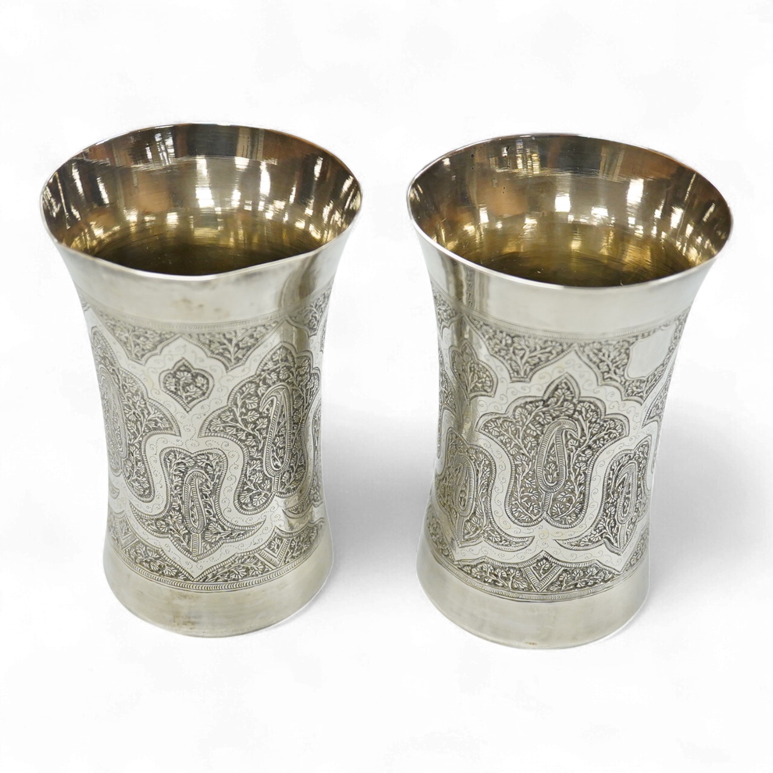 A pair of late 19th century Kashmiri white metal chased waisted beakers, height 12.4cm.
